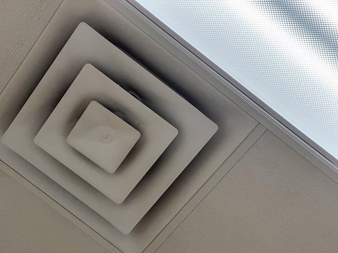 A ceiling HVAC vent cover - the kind of louvered vent that gets painted shut during a repaint